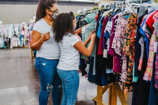 A mother and her daughter shop the racks of clothes at the JBF sale.